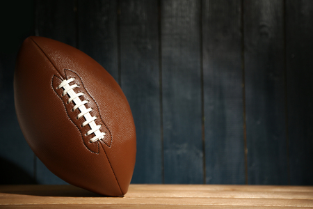 American football on wooden table close up